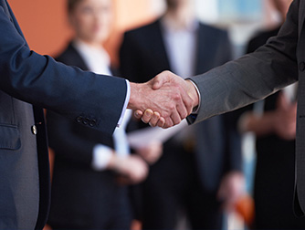 Close up of two men shaking hands.