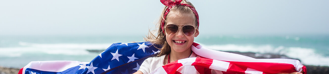 An image of a young girl wrapped in an american flag