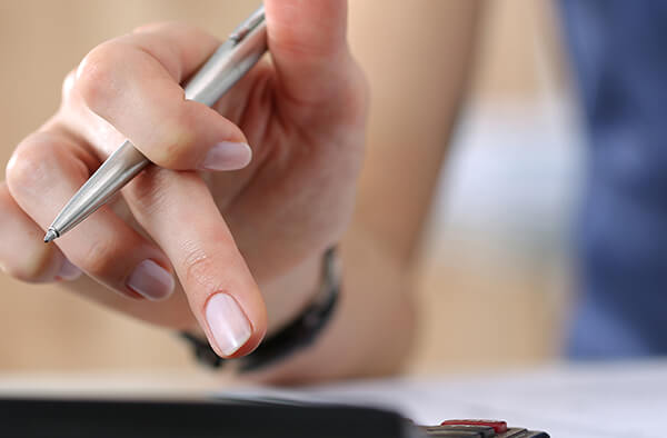 Photo of hand using calculator to review finances.