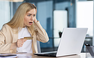 Blond woman with surprised look after she sees her bank account